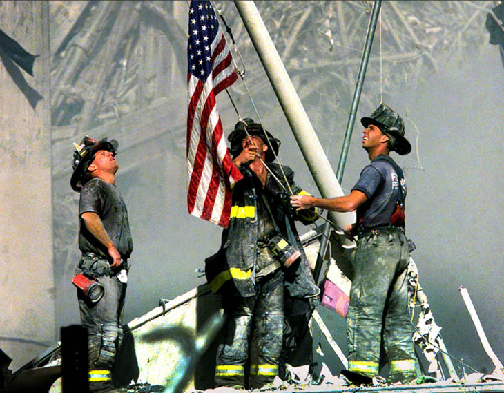 Firefighters raise the American flag on the ruins on the World Trade Centers [2001]