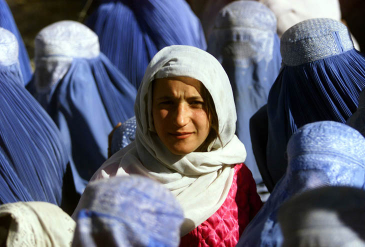 A young Afghan woman shows her face in public for the first time after 5 years of Taliban Sharia law. [2001]