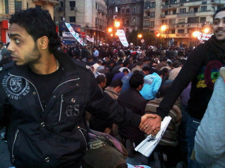 21st century photos - Christians protect Muslims in prayer at Tahrir Square during the Egyptian Revolution [2011]