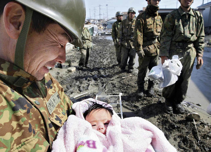 A 4-month-old baby girl is rescued from the rubble four days after the Japanese tsunami. [2011]