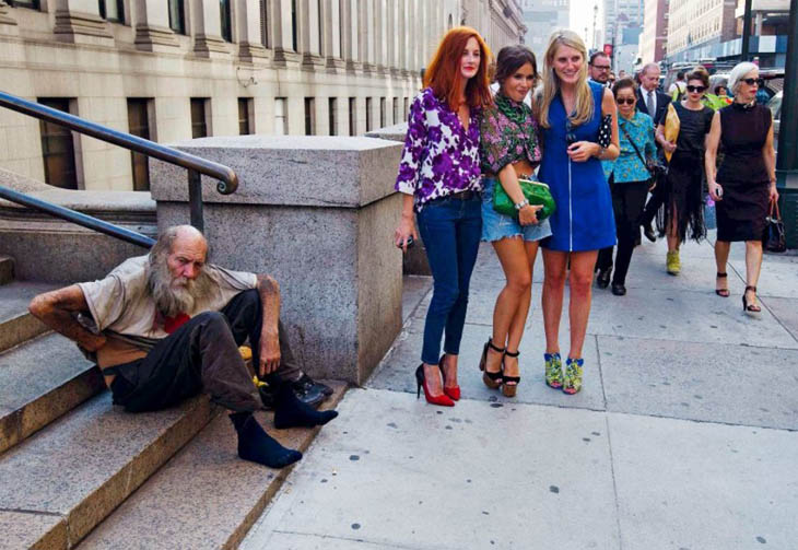 21st century photos - Three young women from the New York Fashion Week pose next to a homeless man. [2012]