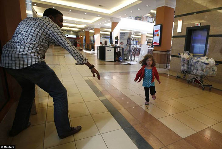 A child runs to safety as armed police hunt gunmen who went on a shooting spree at Westgate shopping centre in Nairobi.