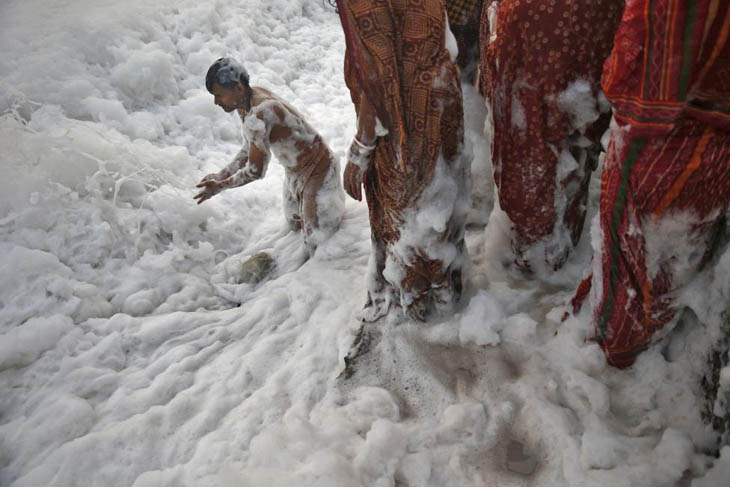 A Hindu devotee worships in the polluted waters of the river Yamuna during the Hindu religious festival of Chatt Puja in New Delhi.