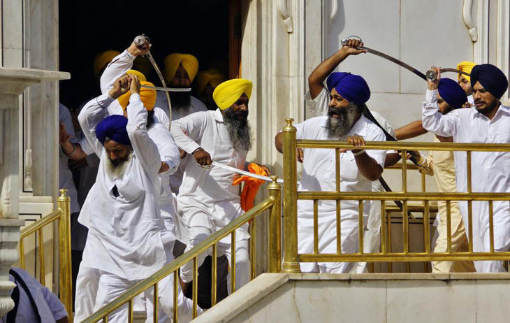 Sikhs wield swords during their clash inside the complex of the holy Sikh shrine, the Golden Temple, in the northern Indian city of Amritsar.