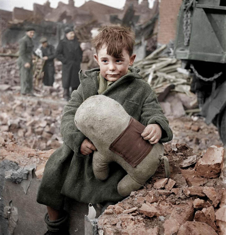 Abandoned boy holding a stuffed toy animal. London 1945