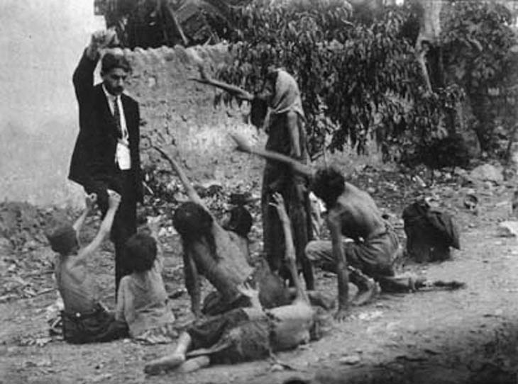 Turkish official teasing starved Armenian children by showing bread during the Armenian Genocide, 1915