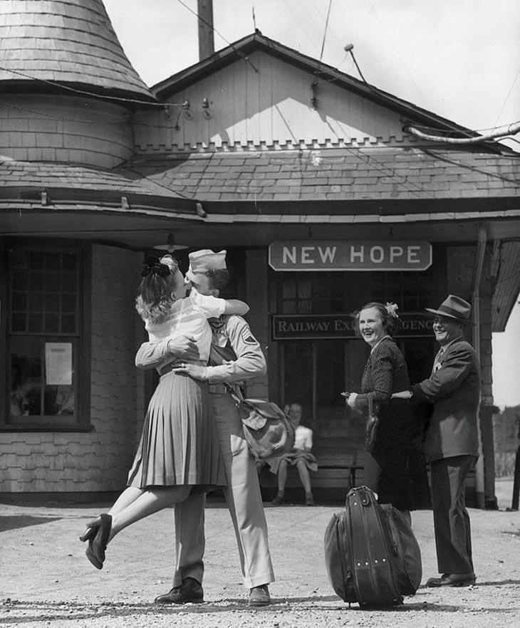 Wartime photos:A Young Woman Lifts Her Feet While Embracing And Kissing A Uniformed Us Soldier